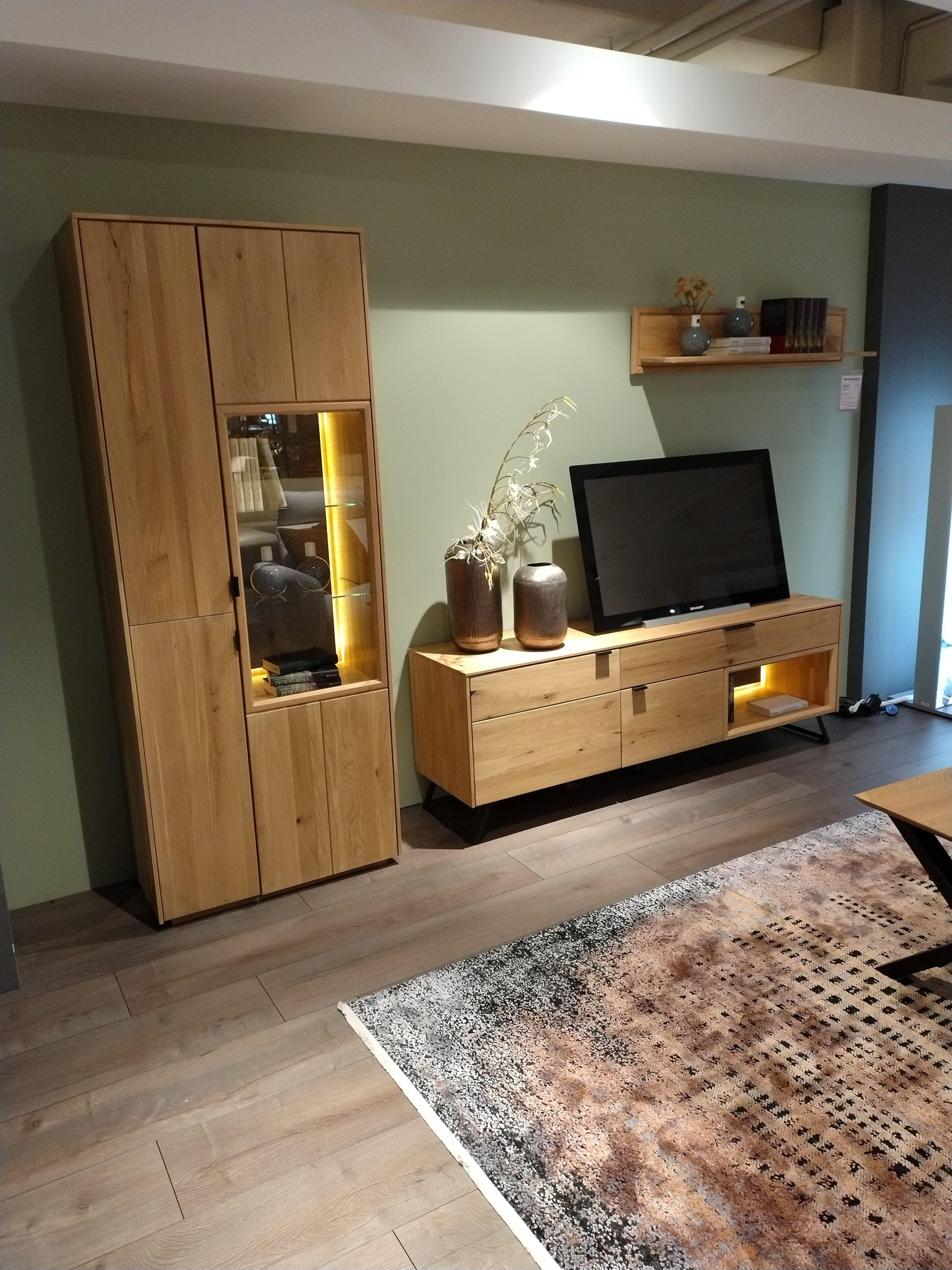 Wohnwand  Eiche Bianco mit Vitrine links, TV-Teil auf schwarzen Metallfüßen und einem Hängewandboard