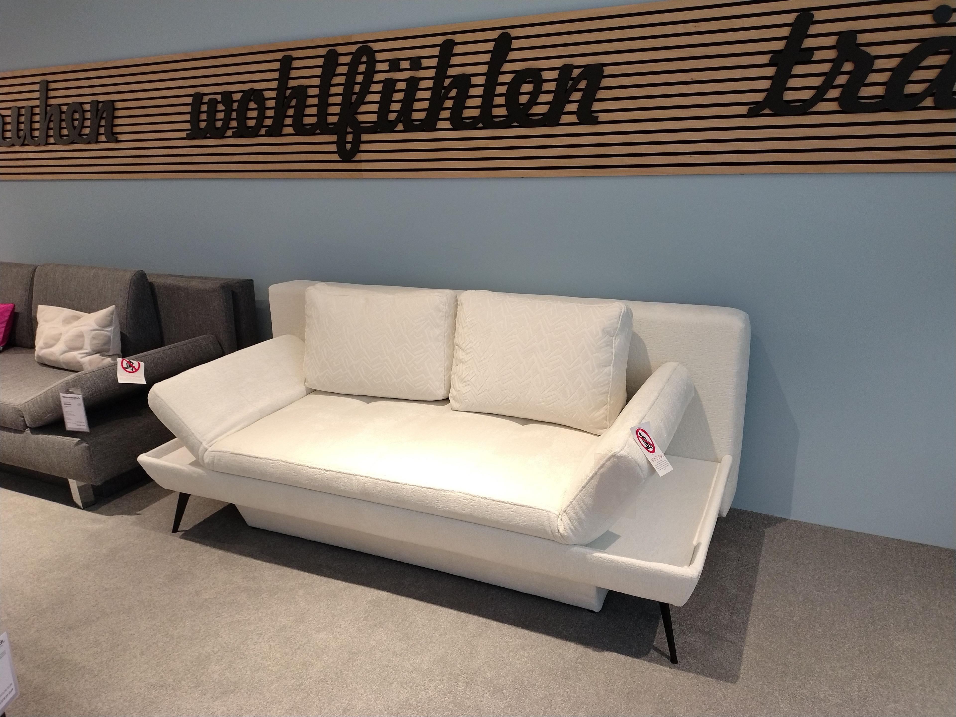 Funktionssofa in hellem Stoff mit 2 Rückenkissen und beide Armlehnen hochgeklappt