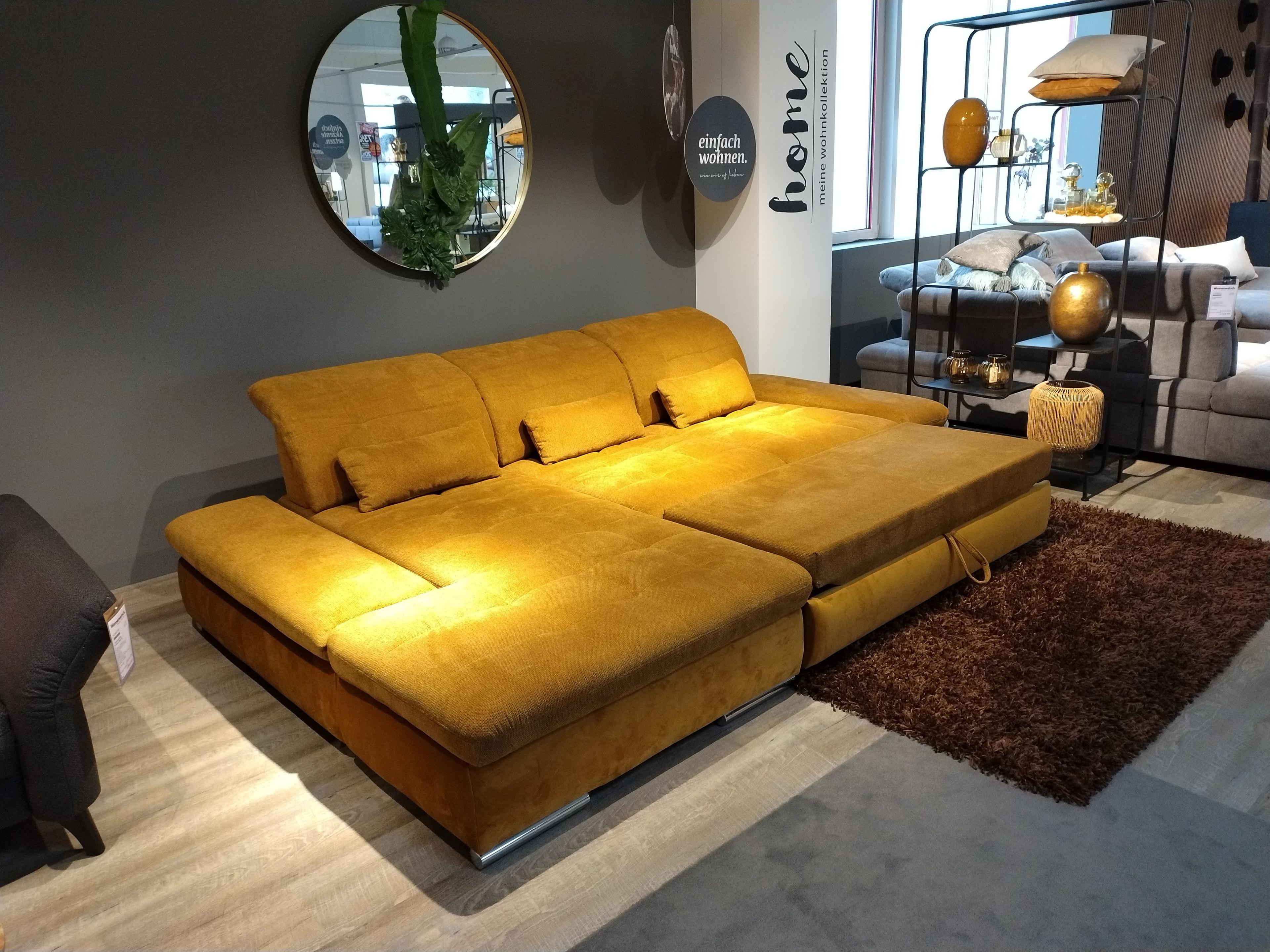 Funktionsauszug ausgezogen bei goldfarbenem Stoffsofa inklusive drei Nierenkissen