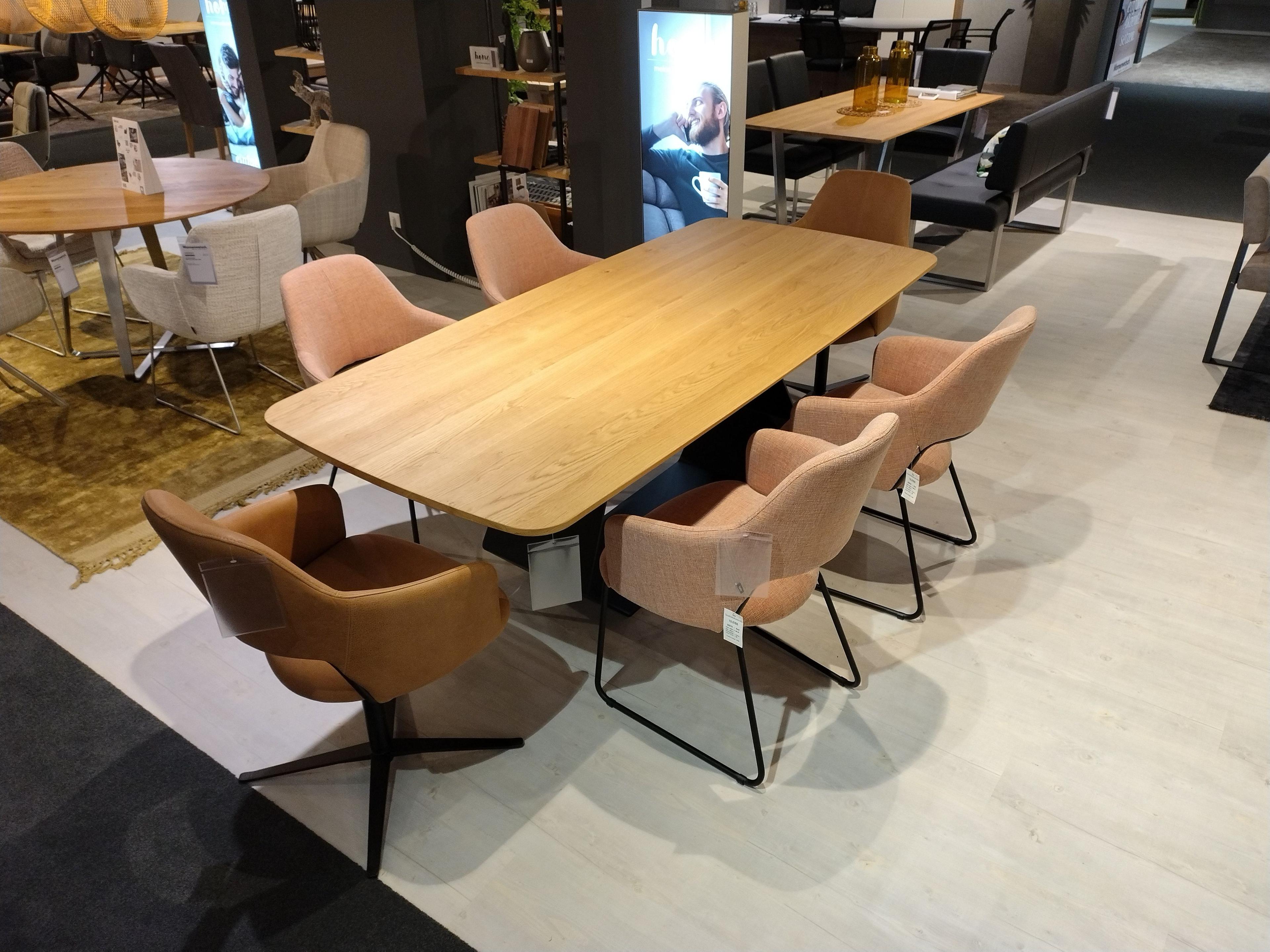 Essgruppe bestehend aus Esstisch Wildeiche hell geölter Platte und massiverem schwarzen Metallgestell zwei Stühle in cognacfarbenem echten Leder drehbar und vier Stühle mit orangefarbenem Stoffbezug und Kufen