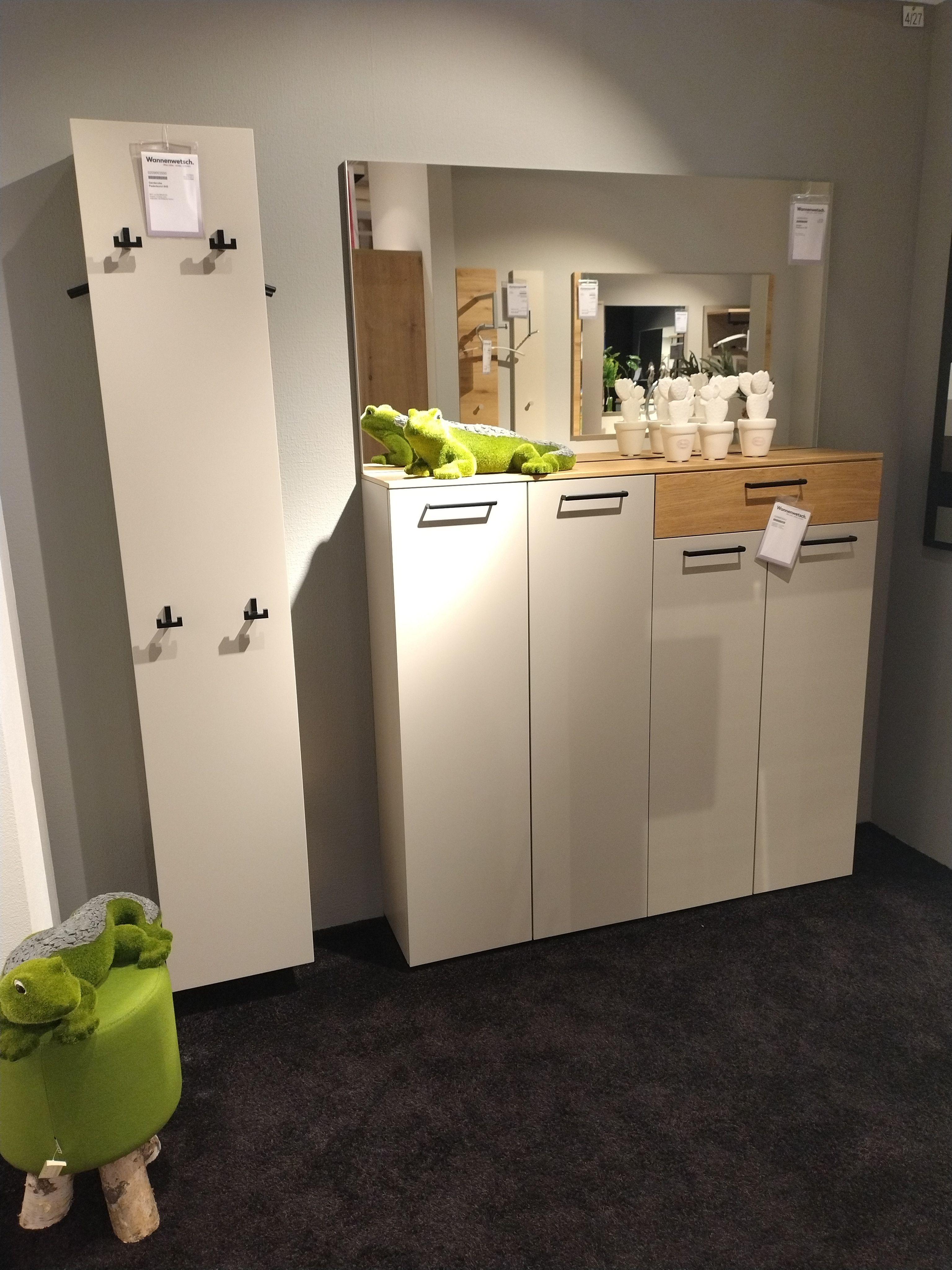 Garderobenkombi bestehend aus einem Paneel links, einem Schuhschrank mit vier Türen und einer Schublade, einem Spiegel der quer über dem Schuhschrank hängt 