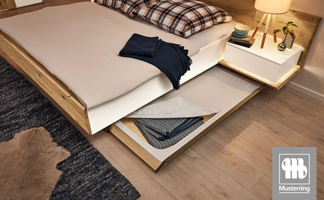 Bett mit ausziehbarem Bettkasten und Holzdetails.
