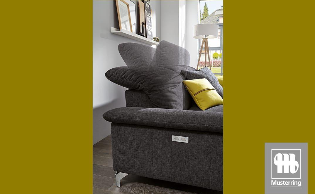 Detail der verstellbaren Rückenlehne und Armauflage eines dunkelgrauen Sofas.