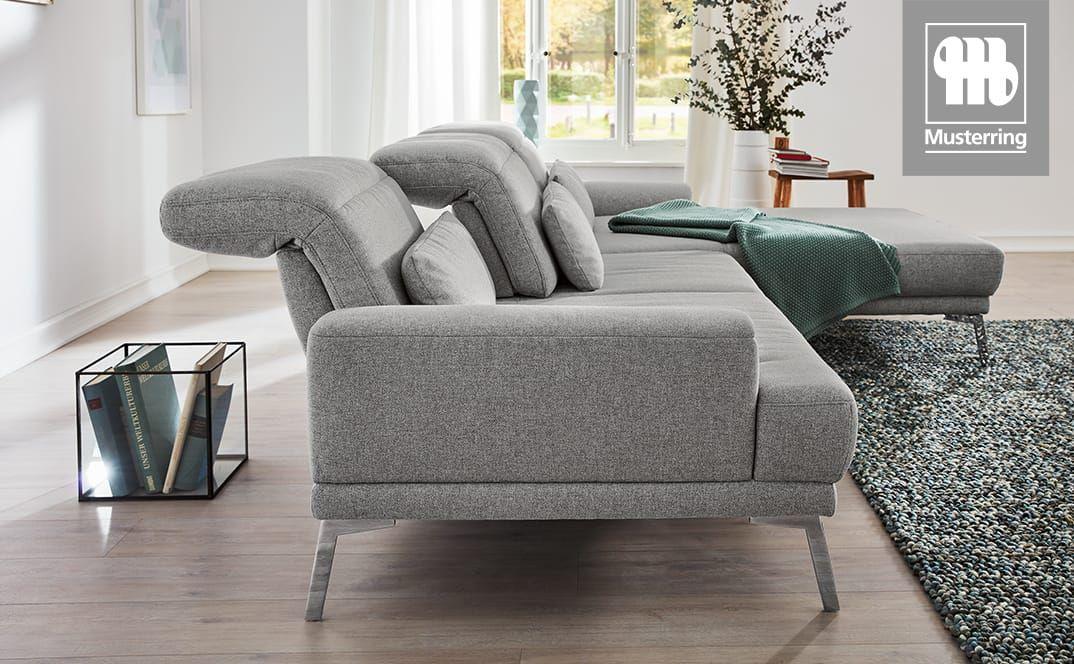 Seitenansicht eines grauen Sofas mit verstellbaren Rückenlehnen und Longchair.