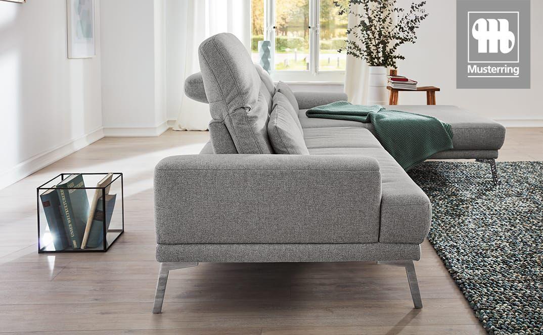 Verstellbare Rückenlehne eines grauen Sofas in leicht aufgerichteter Position.