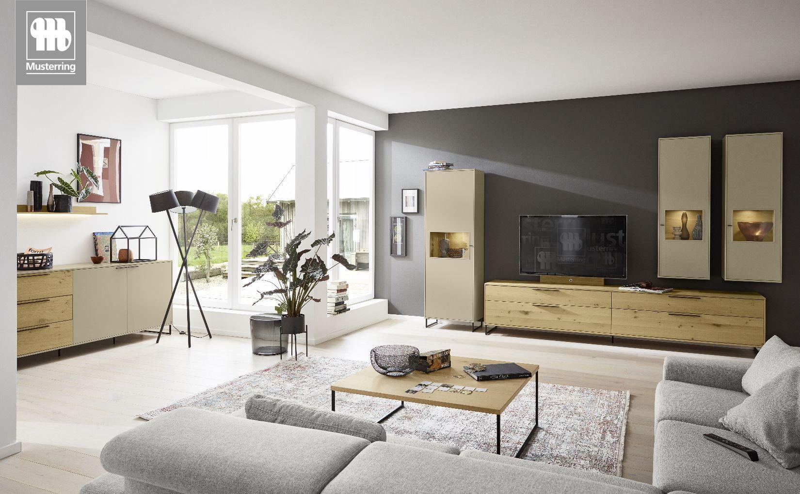 Wohnraum mit MR-Kara-Frame-Wohnwand von Musterring in Eiche und Beige mit Lowboard, Vitrine und Hängeelementen.