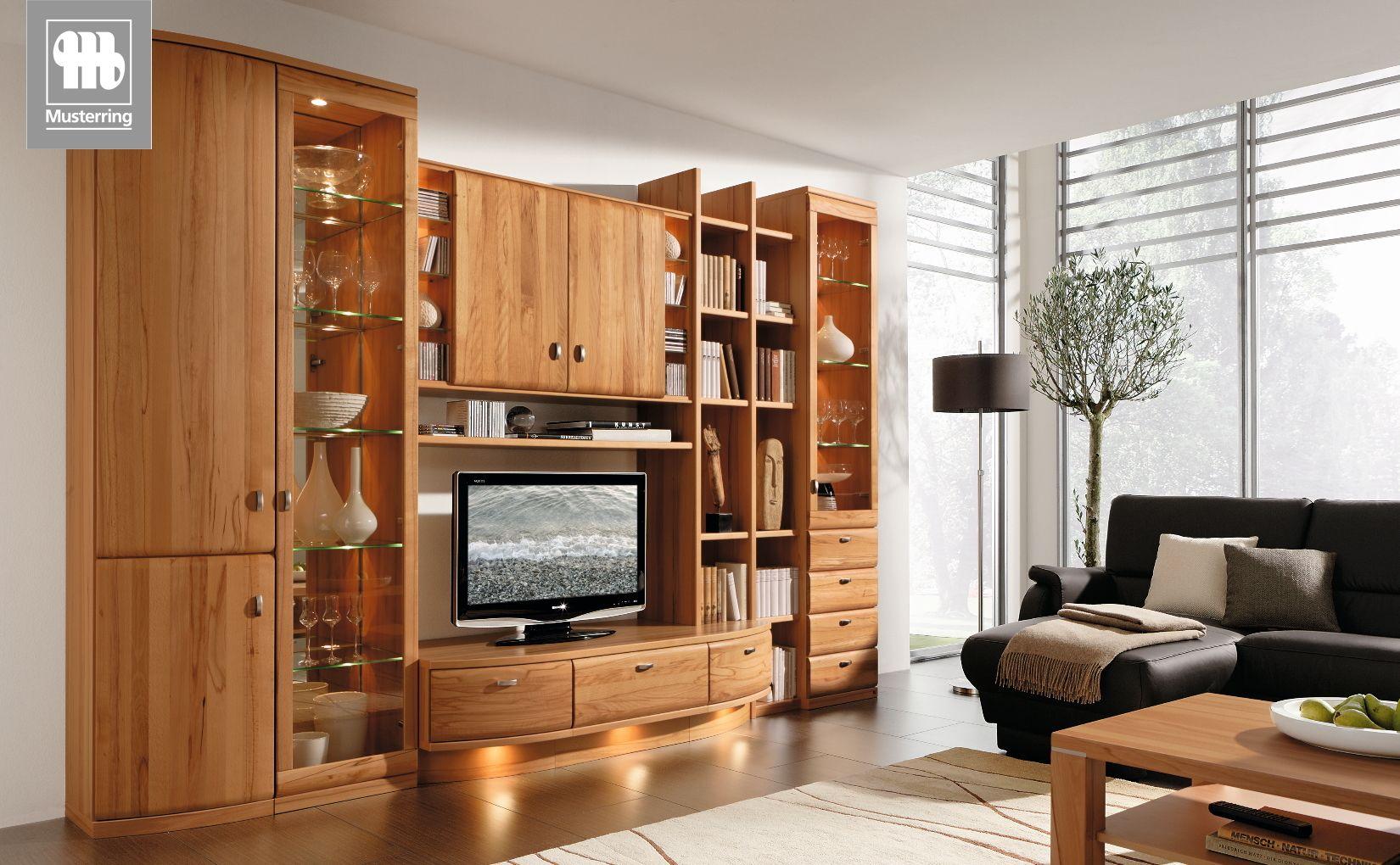 Wohnwand Kiana von Musterring in Kirschbaumoptik mit Glaselementen und offenen Regalen.