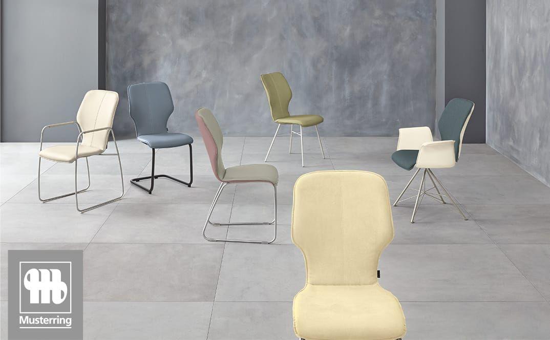 Pastellfarbene Esszimmerstühle in modernem Studio-Setting.