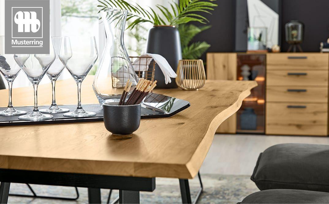 Holztisch mit natürlicher Baumkante und Dekoration.