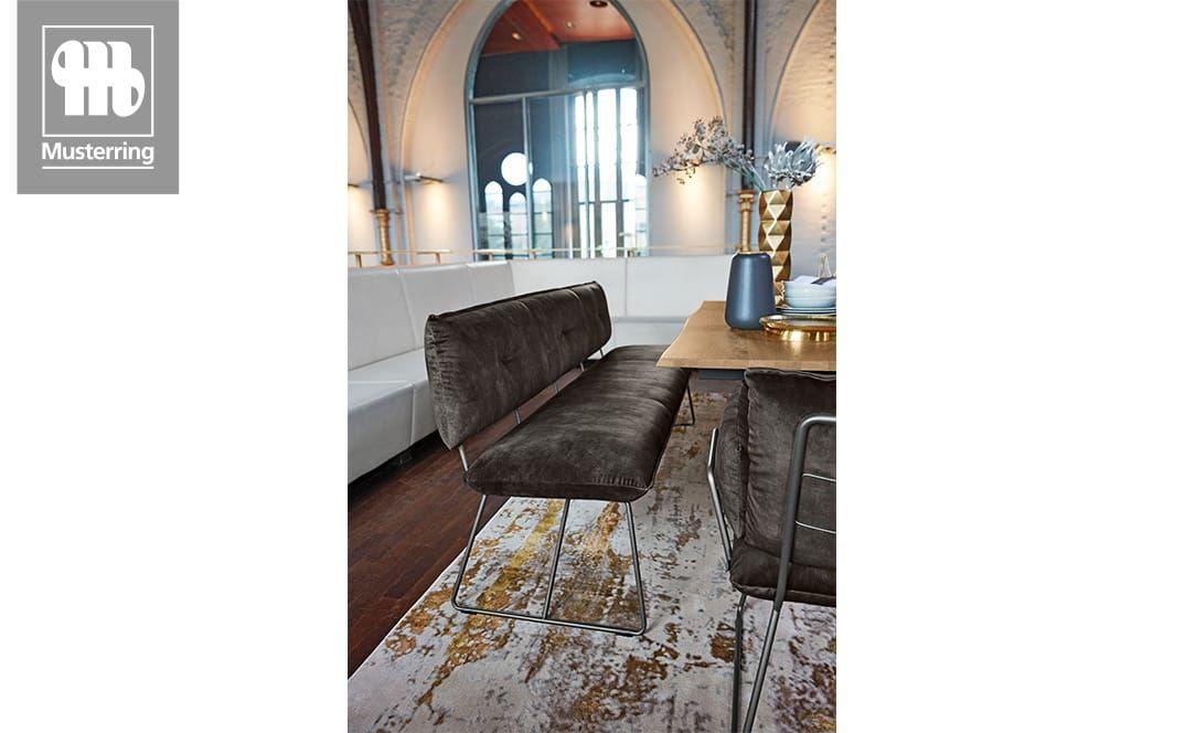 Dunkelgraue Sitzbank an Holztisch in modernem Ambiente.