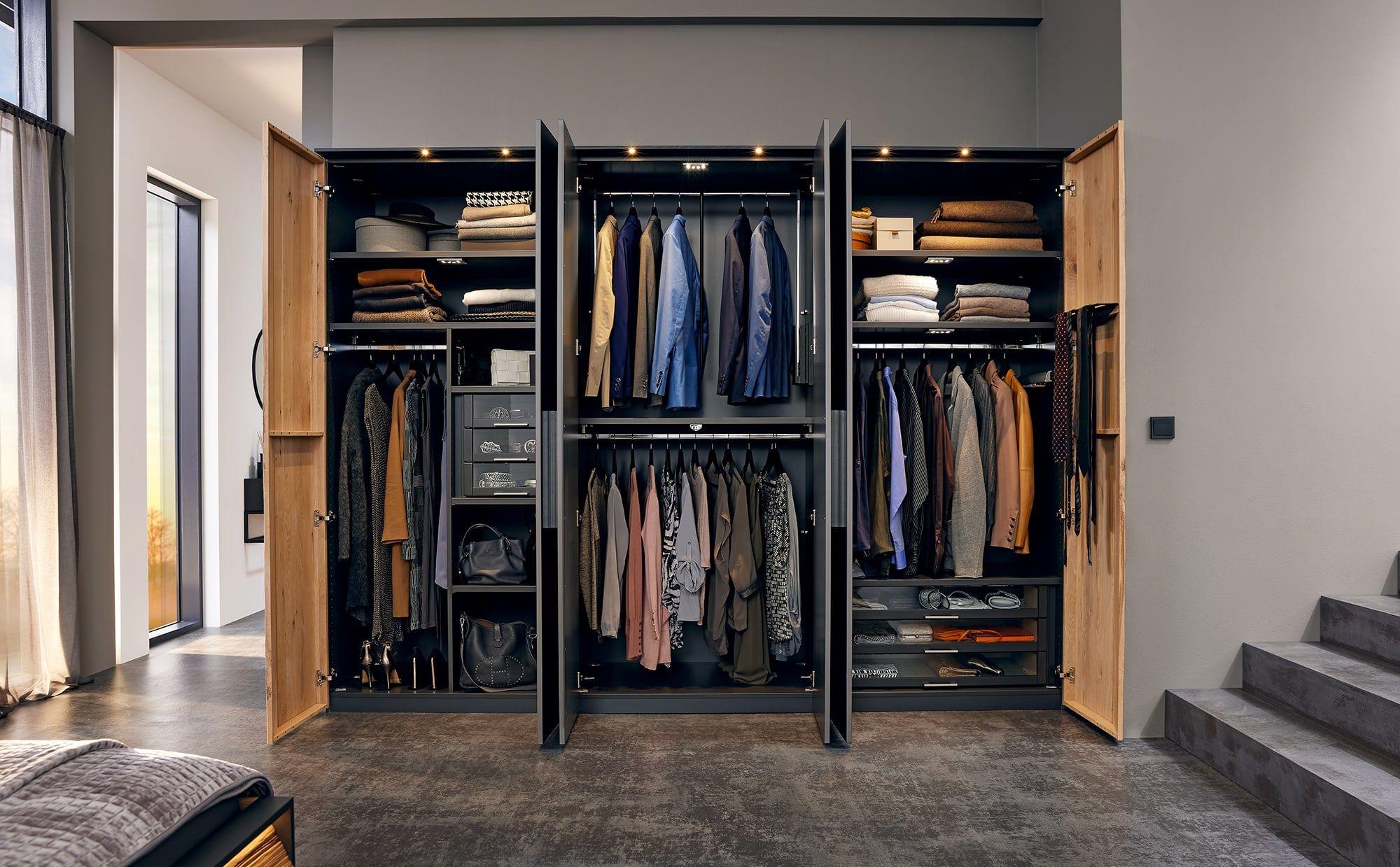 Offener Kleiderschrank mit LED-Beleuchtung und Stauraum in Holz und Anthrazit.