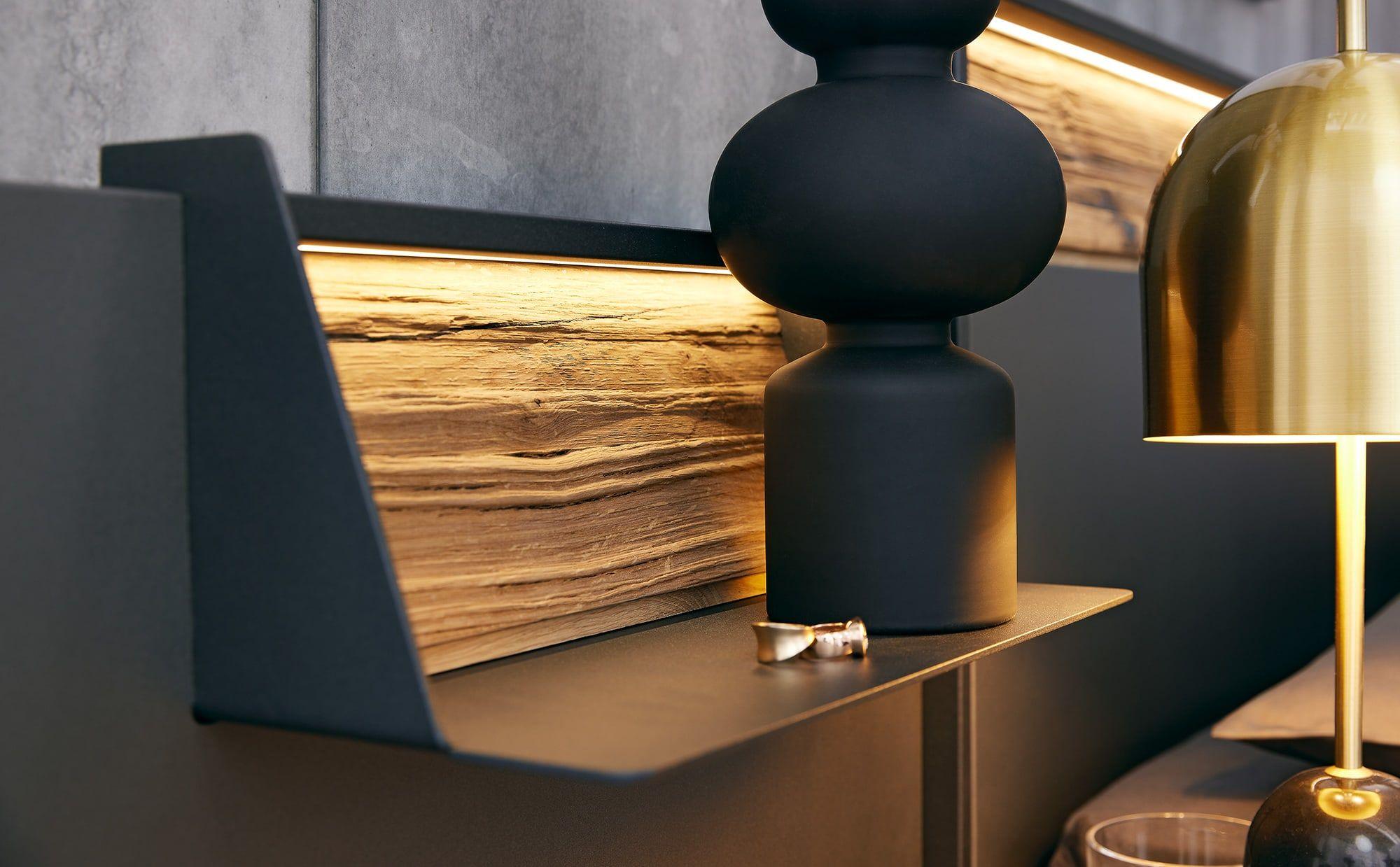 Seitliche Bettablage mit LED-Licht und Holzakzent.