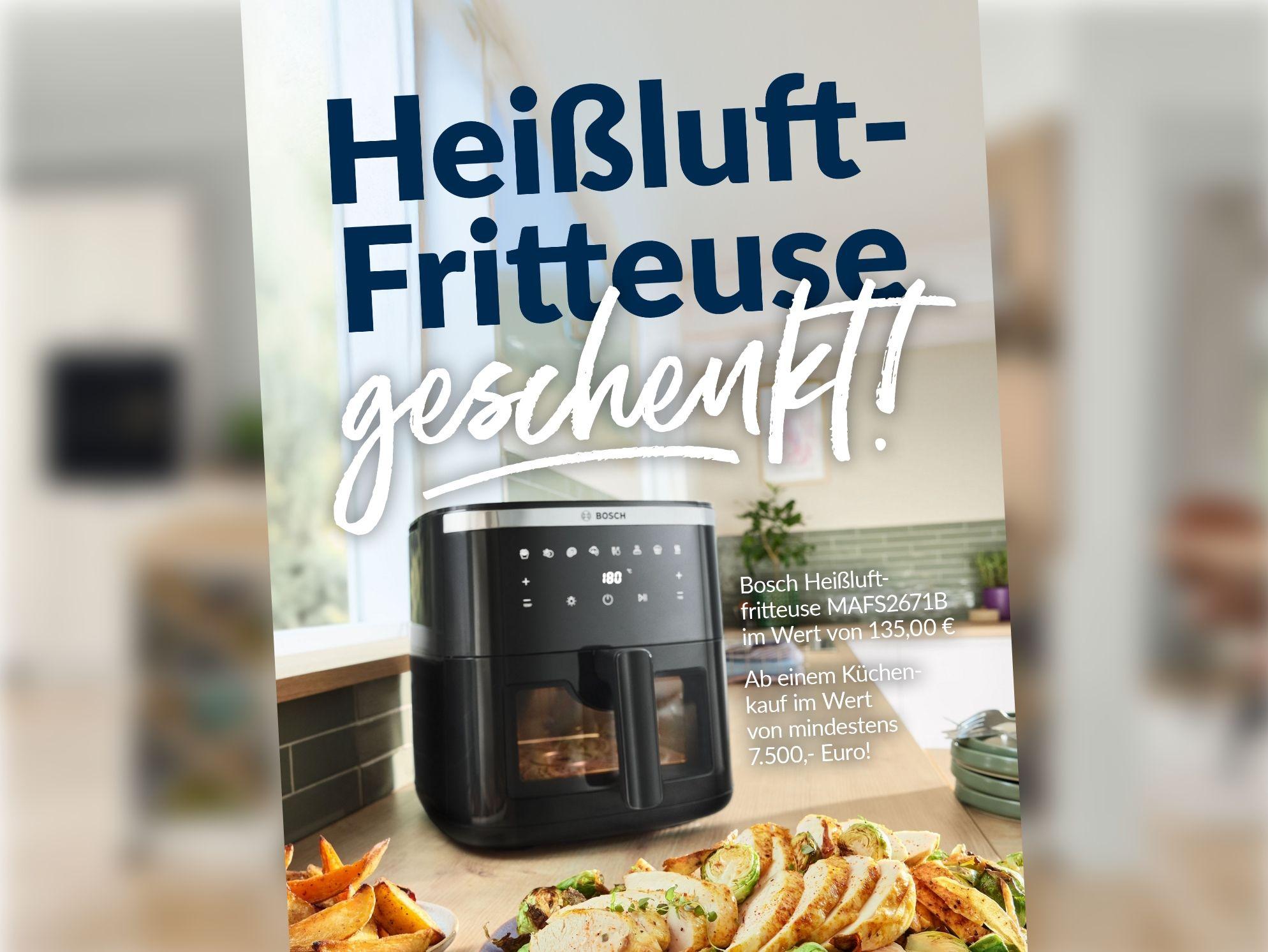 Heißluftfritteuse in moderner Küche mit frisch zubereiteten Speisen als Geschenkaktion.