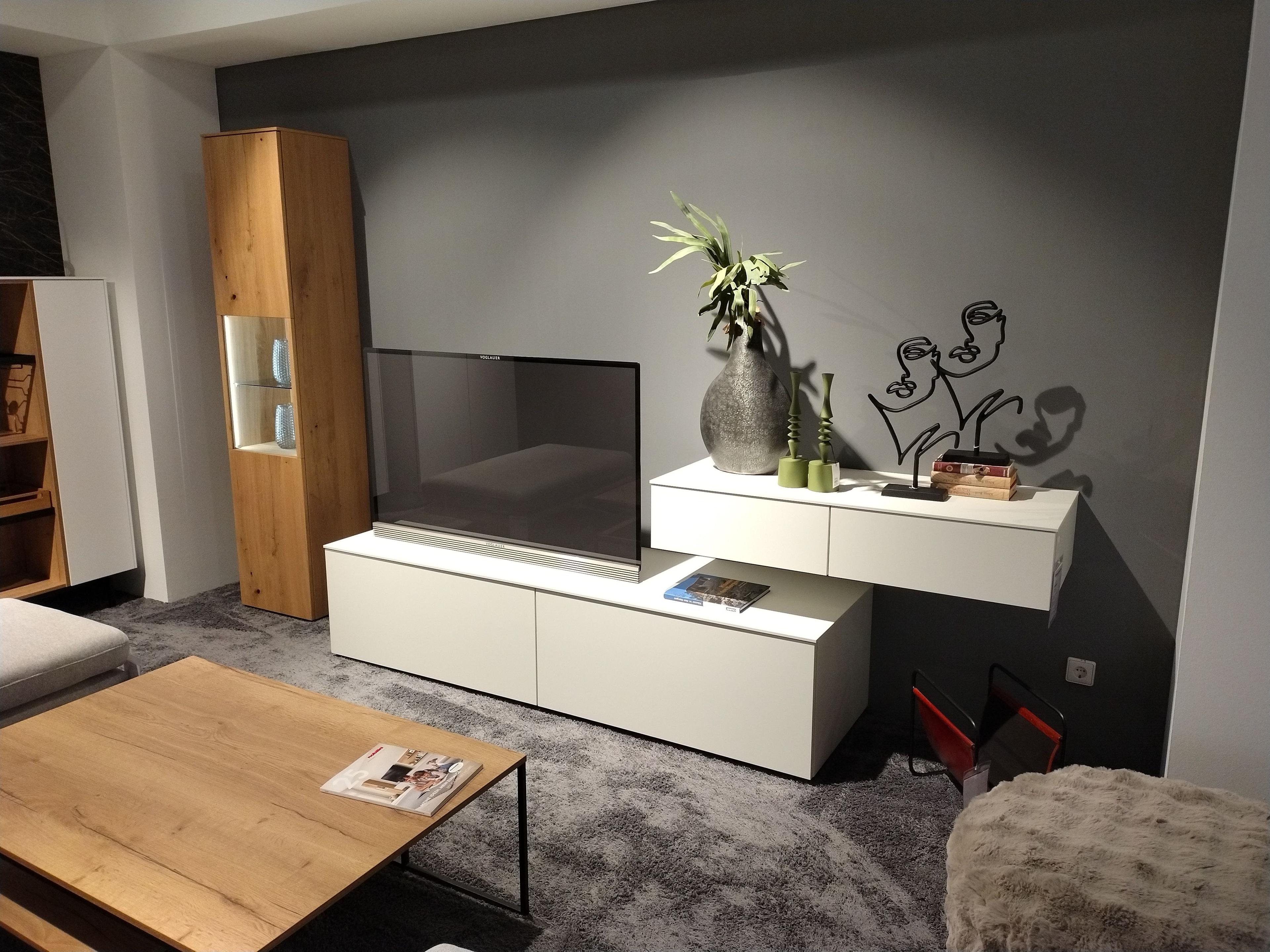 Wohnkombination mit einer Vitrine links in Eiche Echtholzfurnier rechts davon ein weißes TV-Unterteil mit zwei Hängeschubladen in weiß darüber