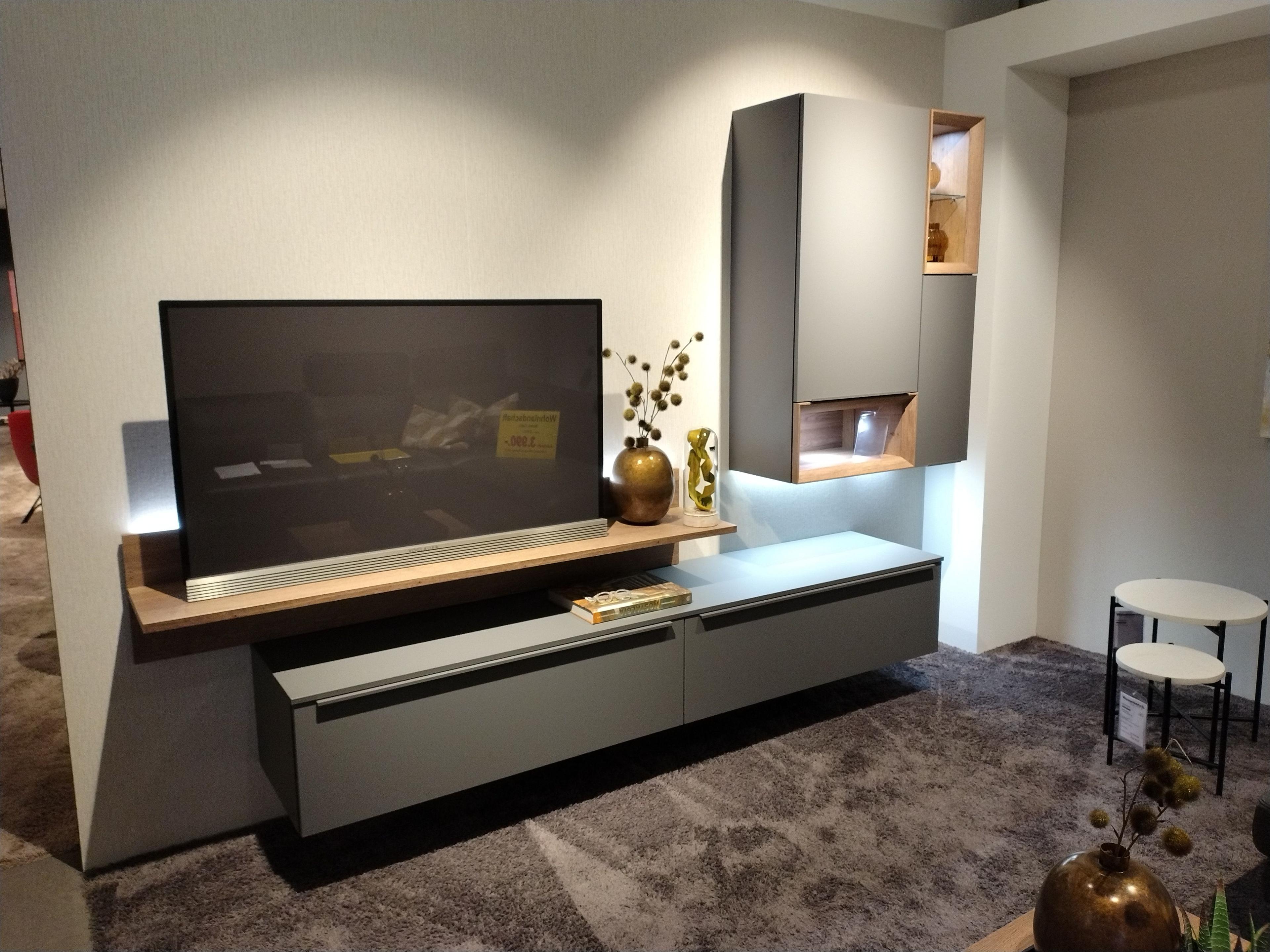 Wohnwand in schiefergrau mit Absetzungen in eiche Sierra Nachbildung hängendes Lowboard darüber hängendes Wandboard für den Fernseher und Hängevitrine