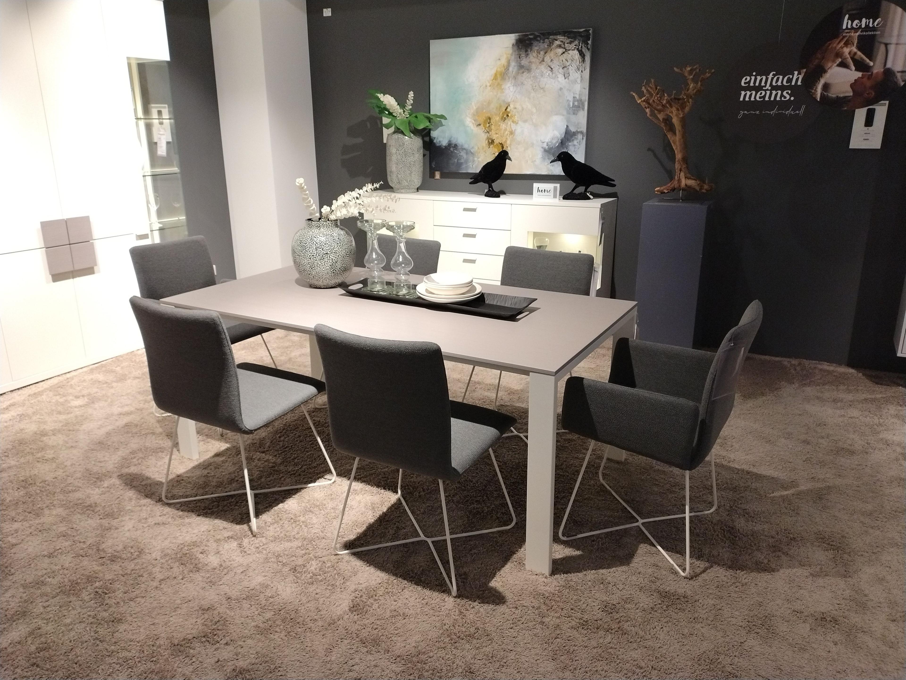 Stuhlgruppe bestehend aus vier Stühlen ohne Armlehne, zwei Stühlen mit Armlehne in grauem Stoff und Kufengestell überkreuz in weiß Metall