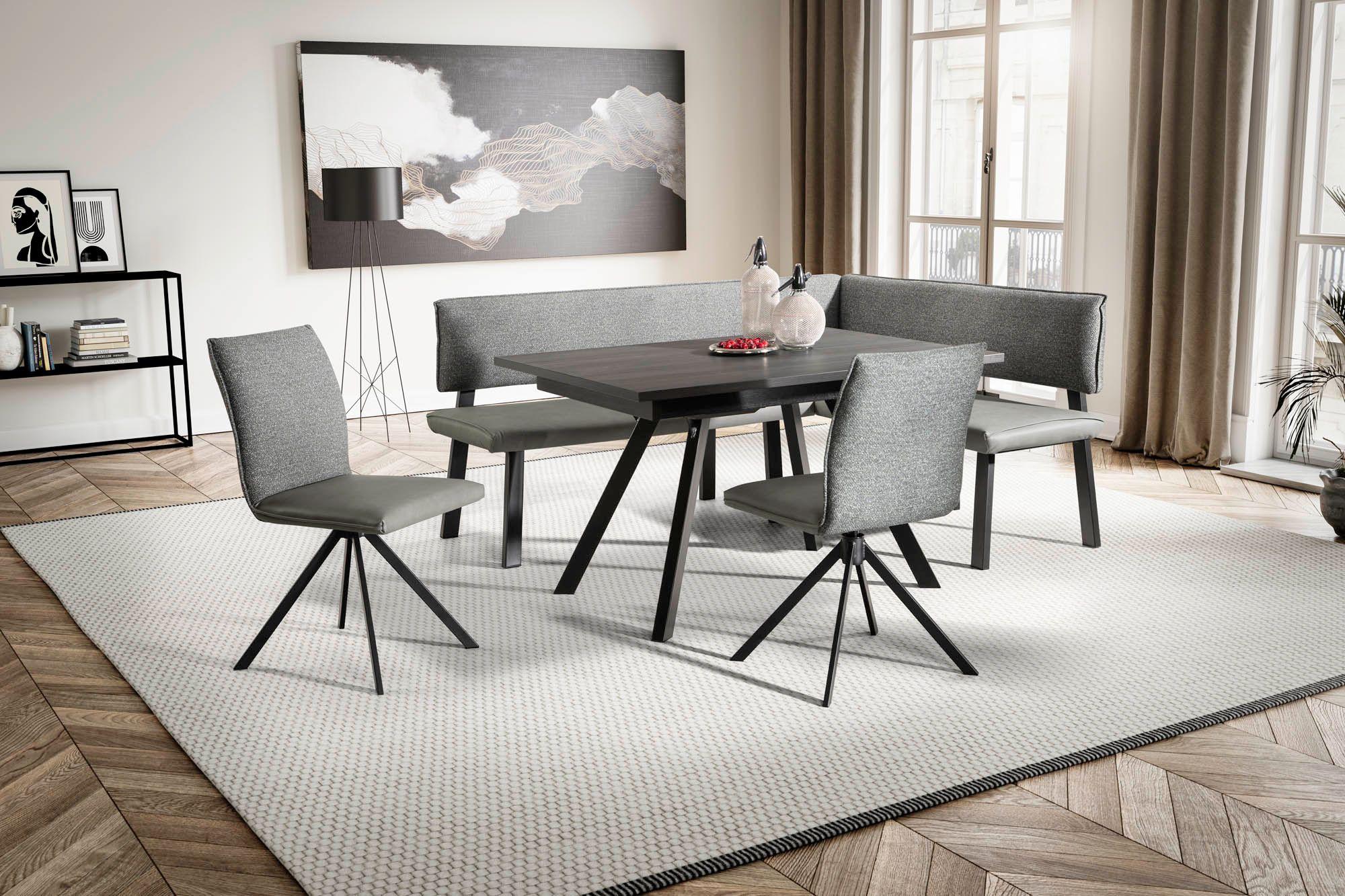 Eckbankgruppe bestehend aus einem Tisch in dunkelgrau mit schwarzem Gestell ohne Auszug, einer Eckbank mit hellem und dunklem grauen Stoff kombiniert, und zwei Stühlen